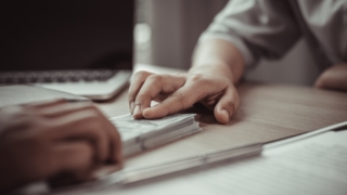 ruka zadržuje peníze na stole